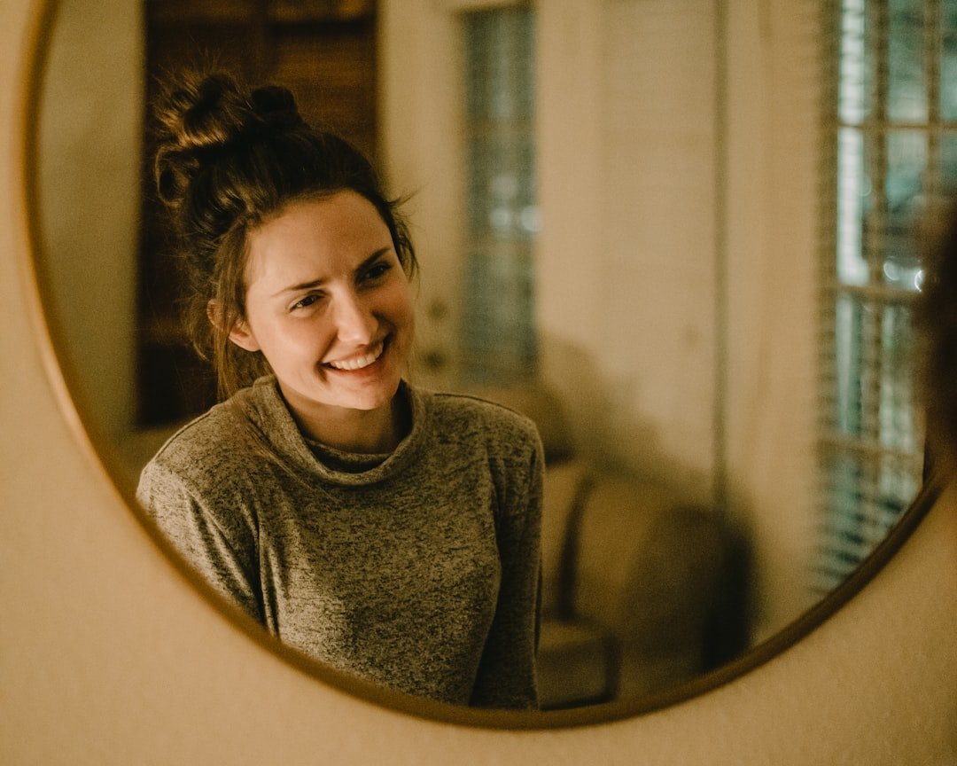 Woman applying simple everyday makeup in a mirror